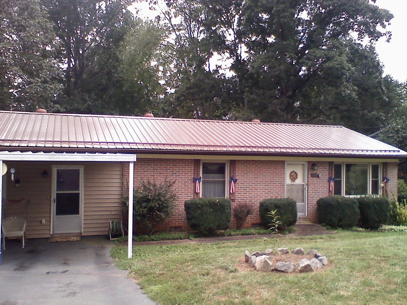 Bronze metal roof and carport on a brick ranch home — Roof Repair work by our crew in Suffern